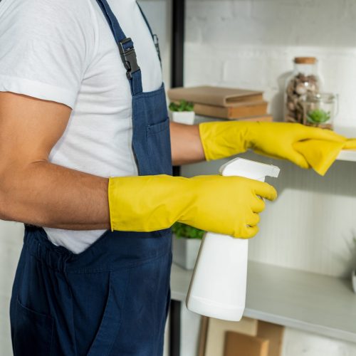 Commercial Cleaning Sunshine Coast - man cleaning with gloves and spray bottle